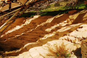 Il koilon (parte della gradinata, riservata agli spettatori) del teatro di Eraclea Monoa è aperto a sud che guarda verso il mare. La protezione è purtroppo volata via in più punti