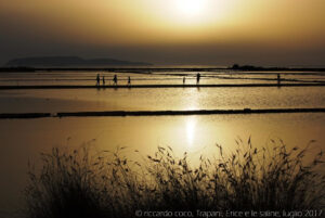 Turisti grandi e piccoli tra le vasche delle "Salina Culcasi" nella "Riserva Naturale Orientata Saline di Trapani e Paceco". Sullo sfondo l’isola di Favignana.