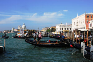 Gondole che vanno e vengono piene di turisti vicino la fermata dei vaporetti “San Zaccaria” lungo la Riva degli Schiavoni a San Marco.