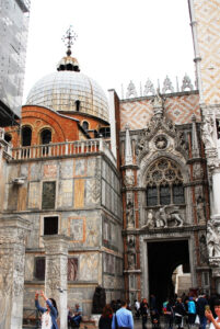Tra la Basilica di San Marco ed il Palazzo Ducale, uno dei due ingressi del Palazzo è la maestosa “Porta della Carta” tutta marmi intagliati con al centro il Leone di San Marco e inginocchiato davanti a lui, il Doge Foscari.